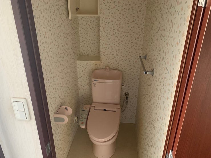 ピンクのトイレと花柄のクロスで可愛らしいトイレです。扉付きの収納がありトイレットペーパーなどの予備も置いておけますね。