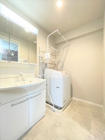 白を基調とした爽やかな洗面所。鏡の後ろは収納になっているので歯磨き粉や髭剃りなども片づけられます。