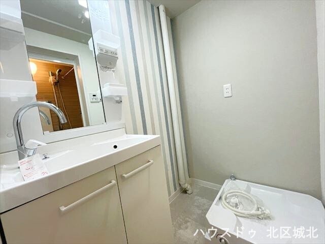 ライト付きの洗面台で見やすく、お肌の手入れや身支度も捗りますね。アクセントクロスが他の部屋と印象を変えてくれます。