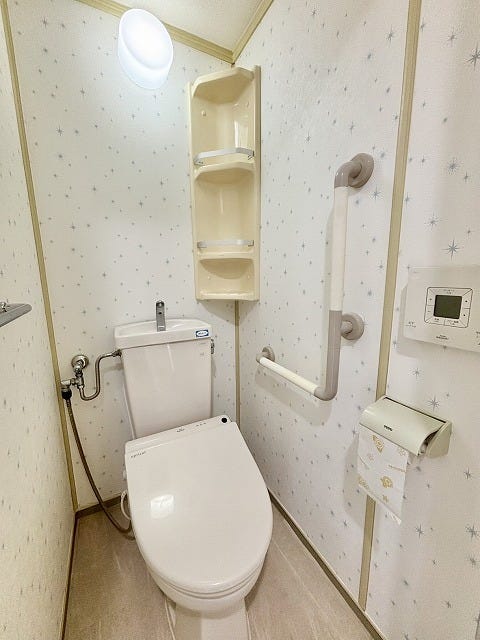 手すりが備え付けられた、白を基調とした清潔感のあるトイレ♪温水洗浄便座つきで、いつでも快適にお使いいただけます♪