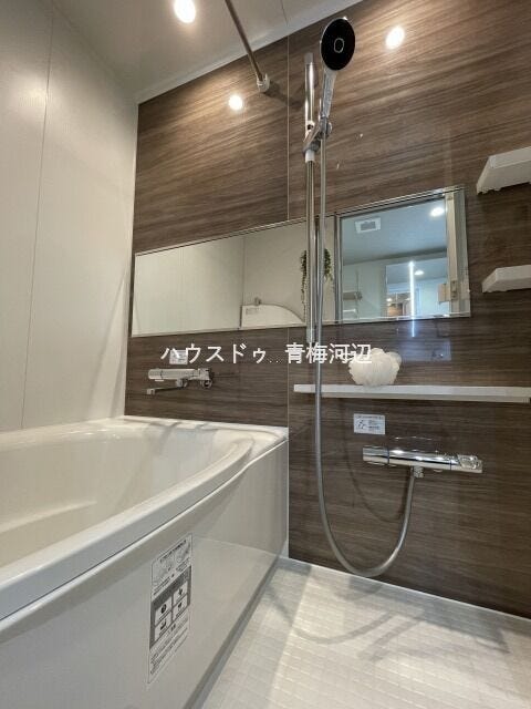 浴室:落ち着いた色合いの壁の切り替えがある浴室です。カウンタースペースや棚があるのでシャンプーなどを置くことができます。