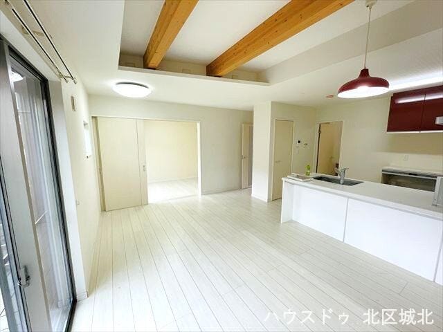 折り上げ天井が開放感を演出するLDK。梁のアクセントと対面キッチンで、明るく広々とした空間です。