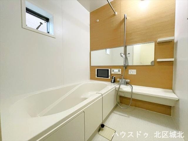 目調の壁が落ち着いた印象を与えてくれる浴室です。棚や小物を置くスペースもついているので、シャンプーなどを置くのに便利ですね。