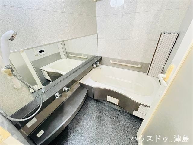 石目模様のアクセントボードを採用した上品で高級感漂うバスルーム。横長の鏡で毎日、ボディチェックができますね。鏡下のカウンターにはシャンプーやボディソープなどを置くのに便利です。浴室暖房乾燥機付きです。