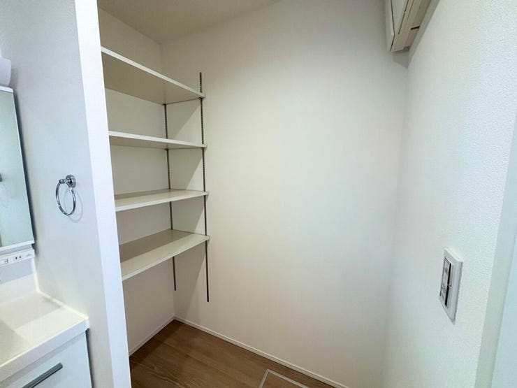 洗面台の横に収納棚を備えた、整った水まわり空間。
洗剤や化粧品などをまとめて収納でき、いつでもスッキリ。
清潔感のある明るい洗面室です。