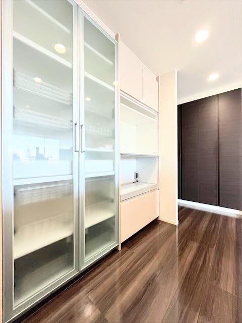 天井まで高さのある白いカップボードを設置した、すっきり広々としたキッチン。豊富な収納スペースで、調理器具や食器類を整理整頓でき、いつでも片付いた状態をキープできます。