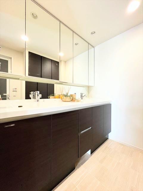 3面鏡の裏側にも収納スペースを確保した、機能的な洗面所です。小物や化粧品もすっきりと整理でき、いつでも清潔な状態を保てます。朝の身支度が快適になりますね。