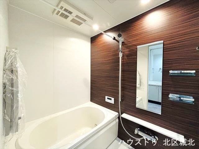 木目調の壁が落ち着いた印象を与えてくれる浴室です。棚や小物を置くスペースもついているので、シャンプーなどを置くのに便利ですね。