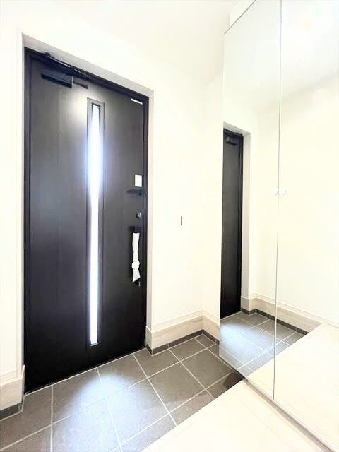 玄関に大きな鏡があると、広々とした印象を与え、光を反射させて明るく開放的な雰囲気に。