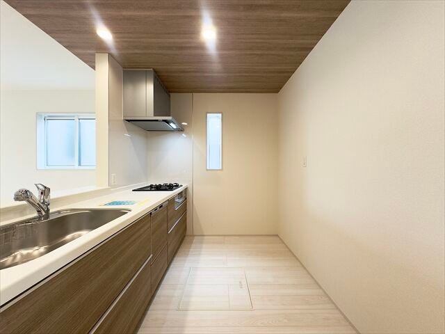 キッチン:窓があり日差しを入れてくれるので、日中は電気をつけなくても明るい空間になっています。後ろ側のスペースにはカップボードを置くことができます。