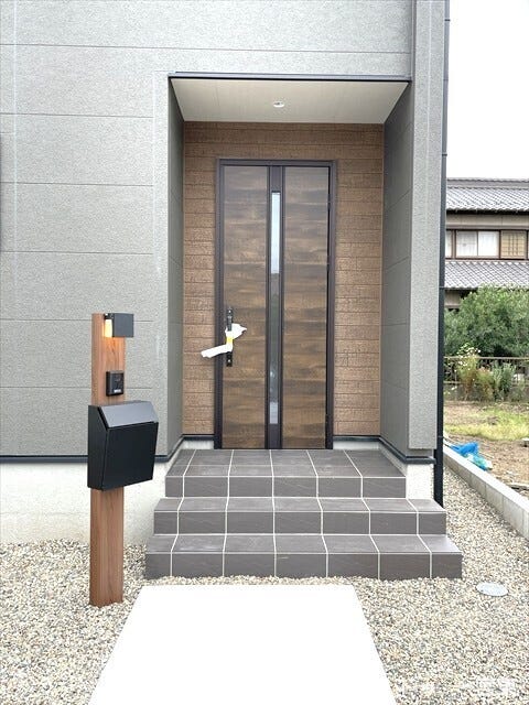 落ち着いた色調で統一されたシックなデザインの玄関です。郵便ポストも外観に調和し、住まいの第一印象を上質かつ洗練された雰囲気に演出します。
