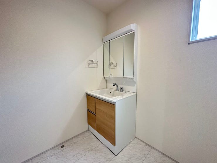 三面鏡の裏側に収納スペースを設置。化粧品や洗面小物などをすっきりと収納できます。