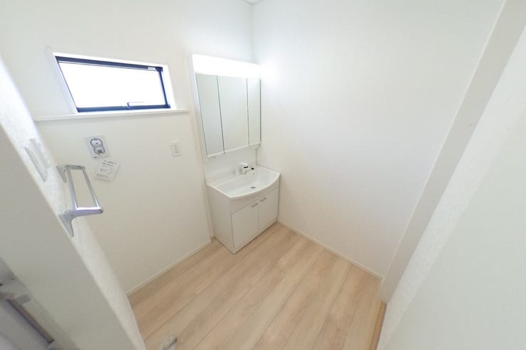 白を基調とした洗面室は明るく、洗面化粧台は女性に嬉しい3面鏡です。壁面収納等を使って使いやすい空間にアレンジできます♪タオル掛けもございます。(甲斐市篠原 新築建売物件)