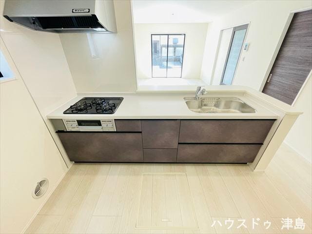 キッチン側はクロスカラーを変えて素敵なアクセントに。浄水機能付き水栓・スライド収納など便利な設備付き。