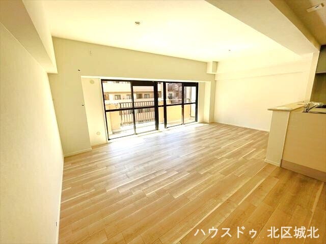 バルコニーからの光が届く広々とした空間です。大きな窓を背に、家具配置のしやすい壁面が確保されているため、ソファやテレビボードもゆったりと設置可能。家族が集い、思い思いに寛げる開放的なリビングです。