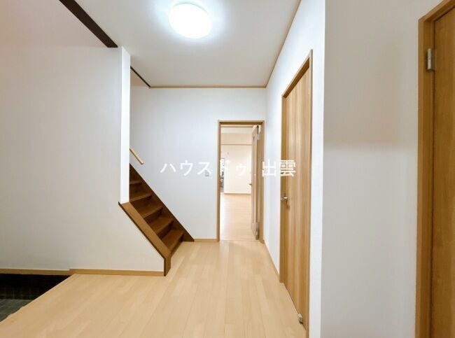 廊下の写真です。壁・天井のクロス張替え、フローリングの重ね張りを行いました。新品の照明に交換いたしました。