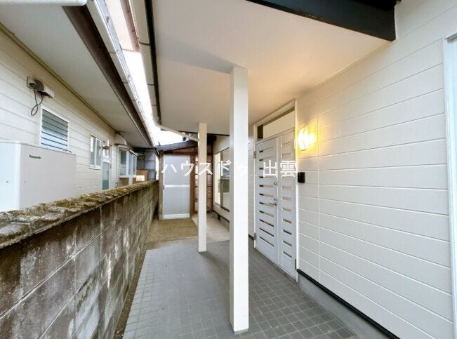 玄関外部の写真です。外壁を白系に塗装しました。真っ白の玄関ドアと白の外壁で明るい印象の玄関です。