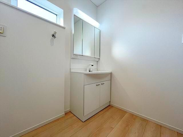 白を基調とした明るく、清潔感のある洗面台です。3面鏡の裏側も収納になっています。(2025年11月14日 撮影)