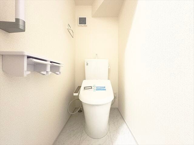 トイレ:ホワイトを基調とした清潔感のあるトイレです。ペーパーホルダーが2つあるのはうれしいですね。その上に小物を置くことができます。