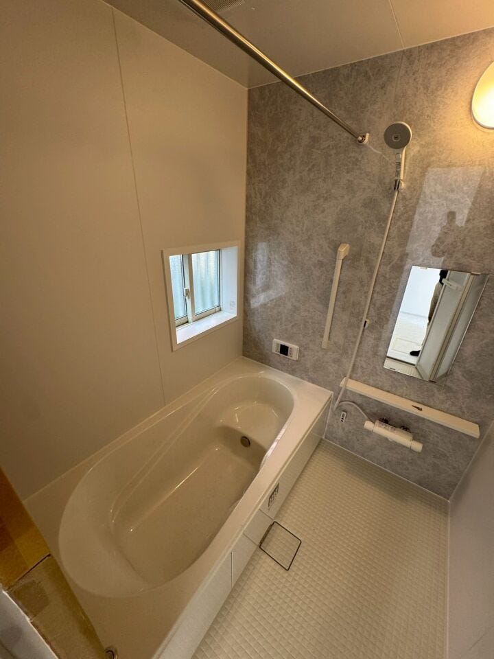 大理石調のアクセントパネルで高級感のあるバスルーム