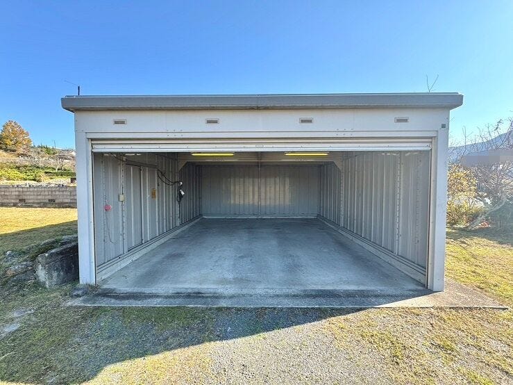 EV充電付きの電動シャッター付車庫で大切なお車の保管が出来ます。車庫の出入り口は高さ約2m、幅員約4.95m、奥行き約6mです。