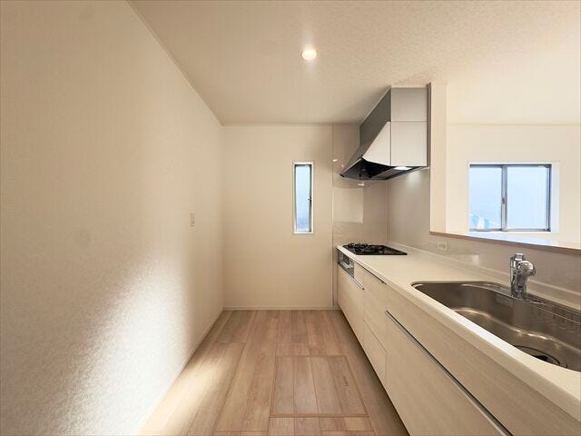 キッチン:窓があり日差しを入れてくれるので、日中は電気をつけなくても明るい空間になっています。後ろ側のスペースにはカップボードを置くことができます。