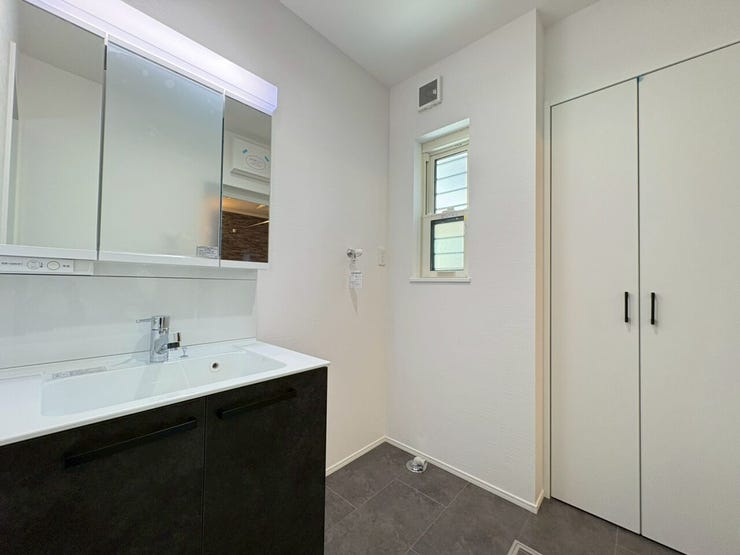 洗面台横の扉付き収納は、タオルや着替えの保管に大活躍!