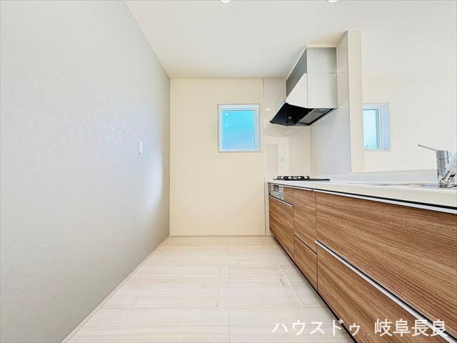 窓から光が差し込み、昼間は照明いらずのキッチン。リビングの方向が見渡せる配置で、家族の様子を見守りながら安心して料理ができます。