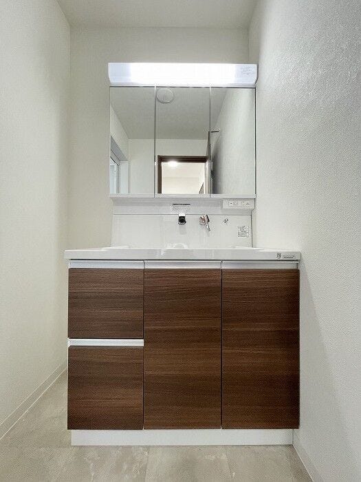 三面鏡の洗面化粧台は鏡扉の裏収納でたっぷりの容量をスッキリと収納できます。シャワーヘッド付きでお掃除も楽ちんです。