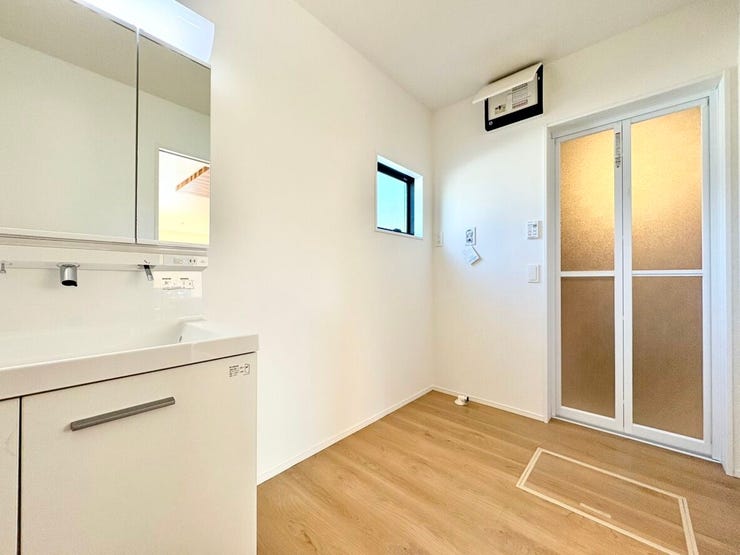 洗濯機を置くスペースも十分に確保されており、広く空間を使うことができます。小窓付きのため、自然光も入り温かい雰囲気の洗面所です。