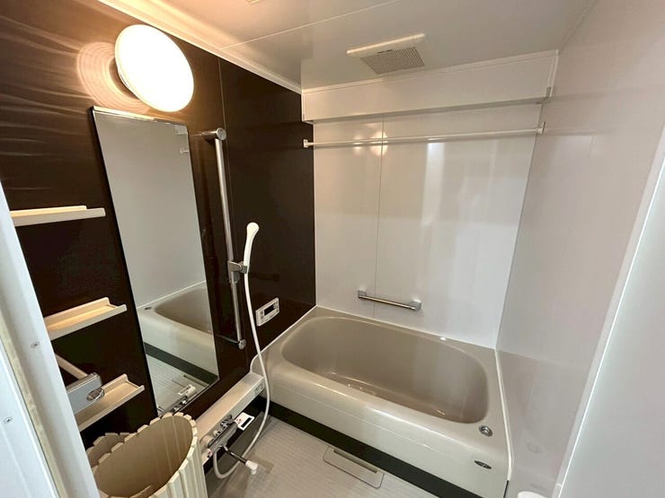 ブラウンのアクセントパネルがおしゃれな浴室。物干し竿も設備されているため、室内干しも可能です。