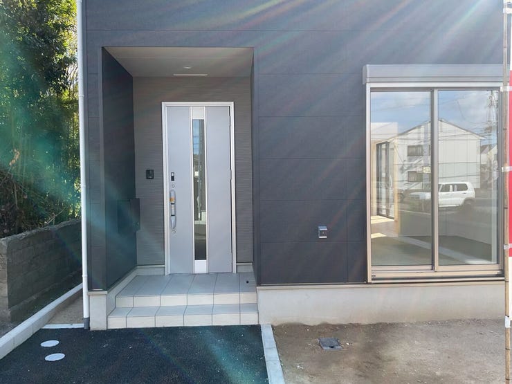 グレーの外壁にシルバーの玄関ドアとサッシです