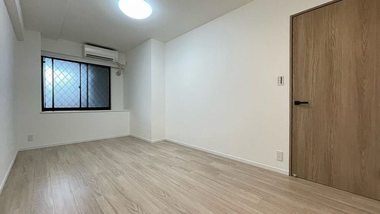 約7.8帖の洋室。白を基調としたシンプルな空間に美しい木目のフローリングが映えます
※エアコンは撤去予定です