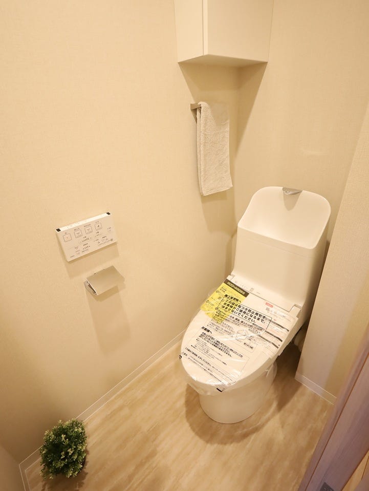 温水洗浄便座タイプの快適なトイレ。上部には収納も付いています。