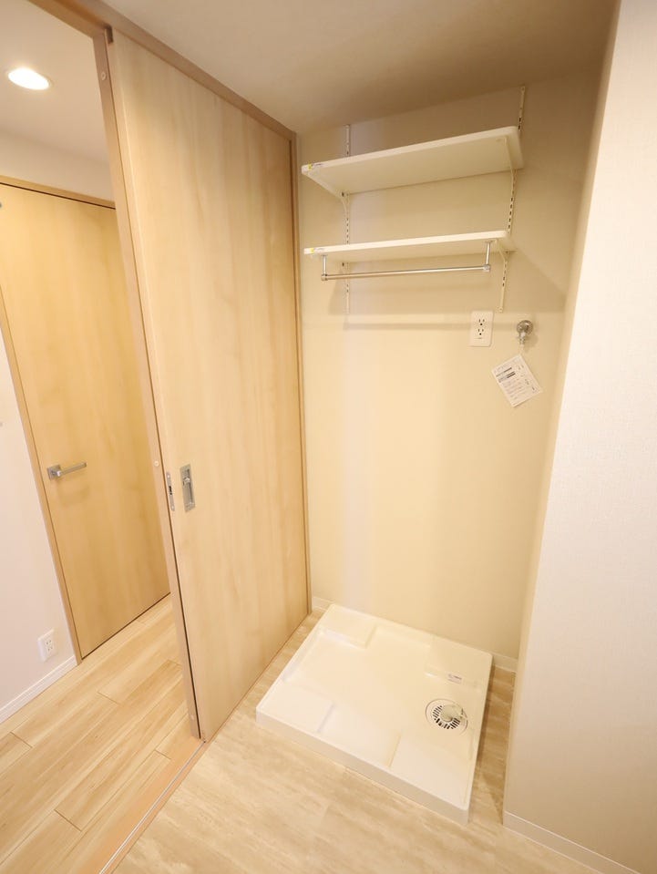 洗濯機置場の上部には吊り棚があり、洗剤やタオル類をすっきり収納。