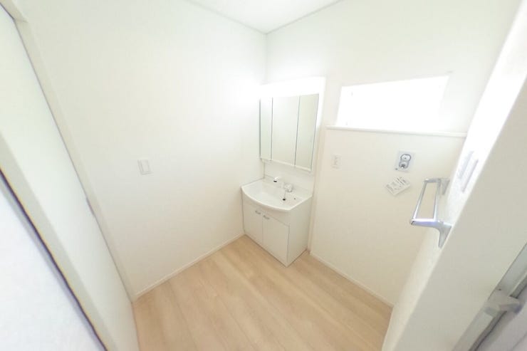 白を基調とした洗面室は明るく、洗面化粧台は女性に嬉しい3面鏡です。壁面収納等を使って使いやすい空間にアレンジできます♪タオル掛けもございます(山梨市下石森 新築建売住宅)