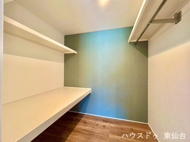 緑のアクセント壁が印象的なウォークインクローゼット。見せる収納と隠す収納をバランスよく備え、毎日の身支度が快適に。