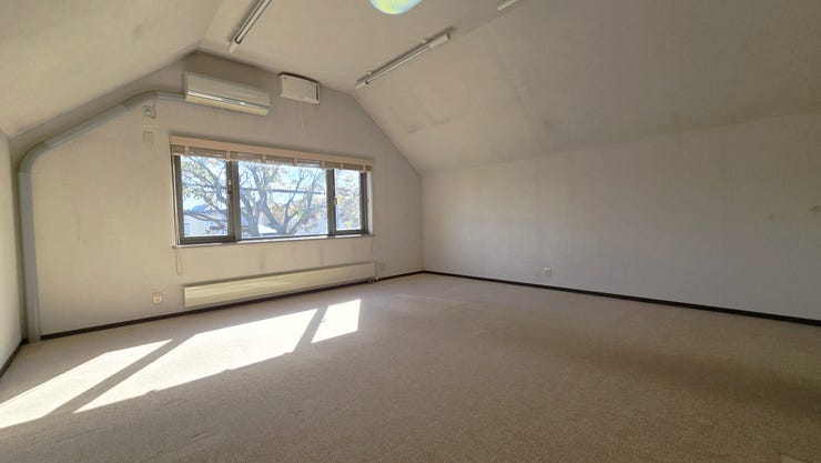 【二階南東側洋室】南東向きで陽当たり良好。勾配天井は、空間に奥行きと開放感をもたらしています。