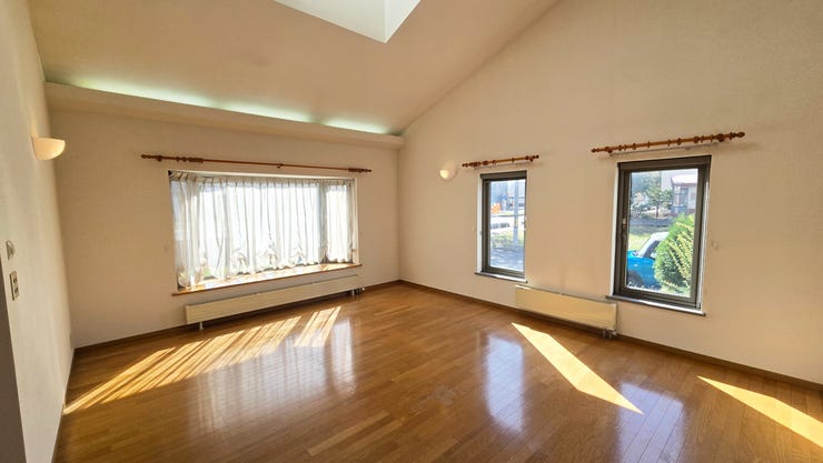 陽光あふれる広々としたリビング。複数の大きな窓からたっぷりと自然光が差し込み、明るく心地よい空間が広がります。