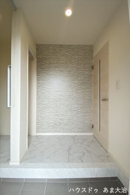 大理石調の床が高級感を演出し、石目調のクロスが上質なアクセントに。上品で洗練された印象の玄関でお客様をお迎えできます。※居住中につき画像を一部加工をしたものです。