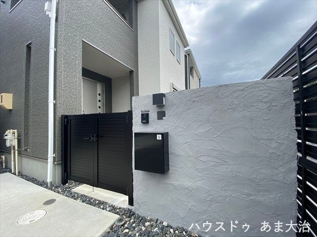 重厚感のあるブラック門柱と塗り壁仕上げの門柱がスタイリッシュな印象。ポスト・インターフォン付きで機能性も兼ね備えた外構です。