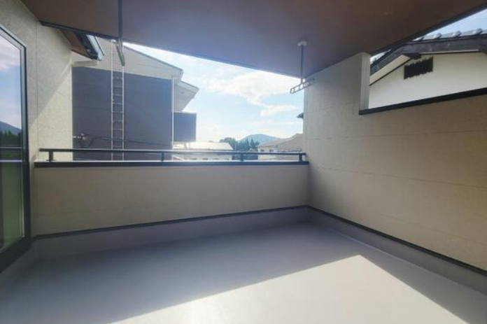 屋根のあるバルコニースペースです。急な雨などに洗濯物干しスペースとして最適。屋外用のテーブルやイスなどを設置することもできます。隣地側の腰壁の高さなど日当たりや目線を工夫された設計になっています。