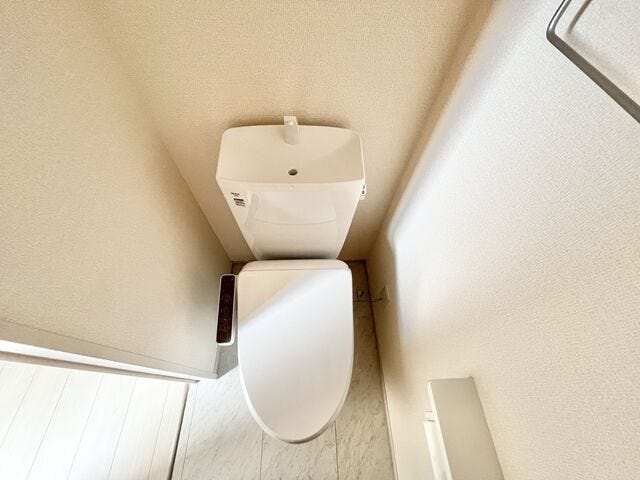 トイレ:ホワイトを基調としたシンプルなデザインの清潔感のあるトイレです。タオルハンガーが備え付けられています。