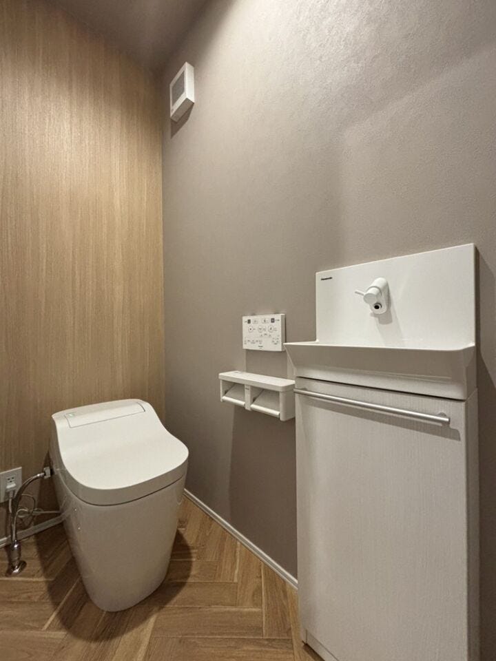 グレー×木目の落ち着いたトーンでまとめたトイレ。タンクレスで見た目もスッキリ!