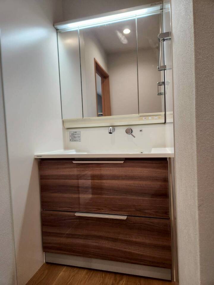 木目調の洗面台が空間に温かみを与えます。