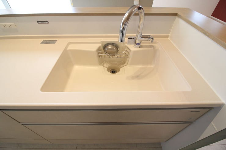 キッチン全体を明るく見せる上品なシンク。洗剤やスポンジがすっきり収まるポケット付きで、水回りを綺麗に保てます。