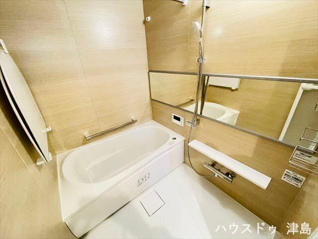 柔らかいナチュラルな印象の浴室。横長の鏡が設置され、毎日ボディチェックができますね。浴室乾燥機が設置され、雨の日でも洗濯物を干すのに助かりますね。