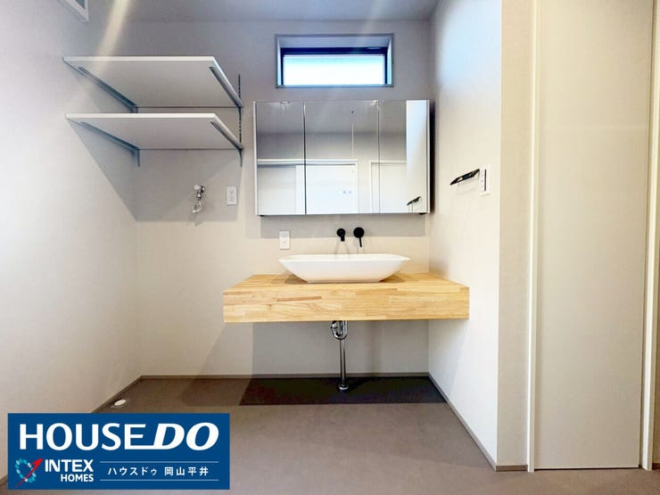 おしゃれな木目のカウンターと洗面ボウルが目を引く、洗練されたサニタリースペース!忙しい朝、家族が並んでもストレスなく使える広さが魅力です。奥には大容量の収納スペースも完備していますよ!