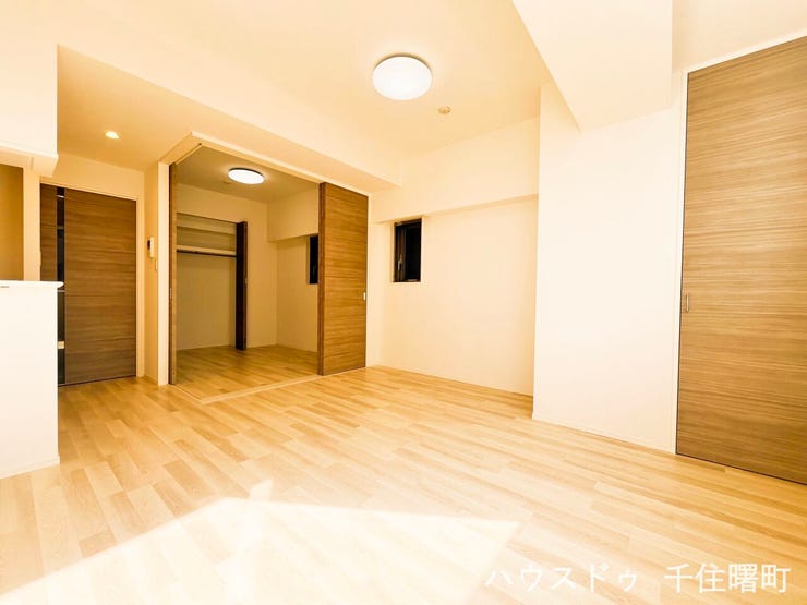 【居間・リビング】
【光と木の温もりに満ちた、家族が集うLDK】
明るいフローリングと木目調の建具が、心地よい空間を演出するリビング・ダイニングです。隣接する洋室の扉を開け放てば、さらに広々とした一体空間に。