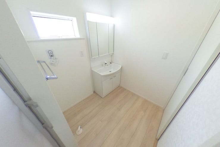 白を基調とした洗面室は明るく、洗面化粧台は女性に嬉しい3面鏡です。壁面収納等を使って使いやすい空間にアレンジできます♪タオル掛けもございます(甲斐市篠原 新築建売住宅)